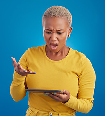 Image showing Tablet, confused and what of woman shocked on stock market crash, risk or online mistake isolated on blue background. Stress, angry and frustrated person on digital technology for app error in studio