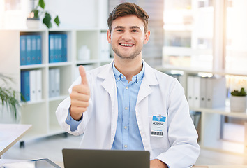 Image showing Thumbs up, doctor and portrait of man in hospital office with laptop for wellness, telehealth and medical research. Healthcare, hand emoji and happy health worker for consulting, yes sign and support