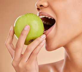 Image showing Apple, dental or mouth of woman eating in studio on beige background for healthy nutrition or clean diet. Bite, hand or zoom of hungry girl advertising or marketing natural green fruits for wellness