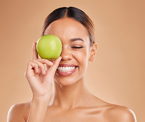 Image showing Beauty, skincare or happy woman with apple in studio on beige background for healthy nutrition or clean diet. Smile, face or girl model laughing or marketing natural fruits for vitamins or wellness
