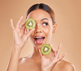 Image showing Kiwi, skincare and face of woman in studio for organic wellness, facial treatment and natural cosmetics. Beauty, spa aesthetic and happy girl smile with fruit for detox, dermatology and healthy skin