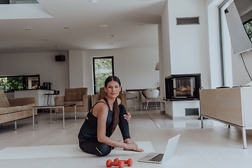 Image showing Young Beautiful Female Woman with Trainer via Video Call Conference in Bright Sunny House. Healthy Lifestyle, Wellbeing and Mindfulness Concept.