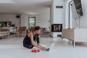 Image showing Young Beautiful Female Woman with Trainer via Video Call Conference in Bright Sunny House. Healthy Lifestyle, Wellbeing and Mindfulness Concept.