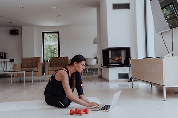 Image showing Young Beautiful Female Woman with Trainer via Video Call Conference in Bright Sunny House. Healthy Lifestyle, Wellbeing and Mindfulness Concept.