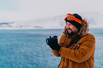 Image showing A photographer in the cold Skavdinava regions tries to take a photo for journalism in a strong winter storm