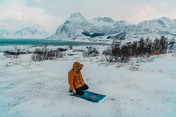 Image showing A Muslim traveling through arctic cold regions while performing the Muslim prayer namaz during breaks