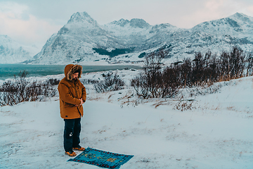Image showing A Muslim traveling through arctic cold regions while performing the Muslim prayer namaz during breaks