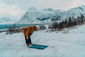 Image showing A Muslim traveling through arctic cold regions while performing the Muslim prayer namaz during breaks