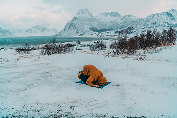 Image showing A Muslim traveling through arctic cold regions while performing the Muslim prayer namaz during breaks