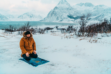 Image showing A Muslim traveling through arctic cold regions while performing the Muslim prayer namaz during breaks