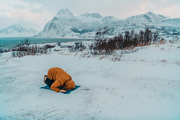 Image showing A Muslim traveling through arctic cold regions while performing the Muslim prayer namaz during breaks