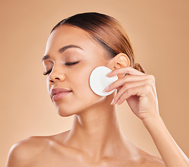 Image showing Cleaning face, cotton and beauty of woman in studio with dermatology, cosmetic and detox. Aesthetic female with hand for natural facial makeup clean, self care and skincare glow on brown background