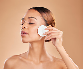 Image showing Skincare, cotton and woman in studio for cleaning, wellness and toner on brown background. Face, beauty and girl model with facial pad for makeup removal, glowing skin or aesthetic while isolated