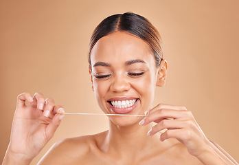 Image showing Happy, dental floss and woman in studio for teeth, cleaning and oral hygiene against brown background. Mouth, flossing and girl model with thread for tooth, decay and prevention while posing isolated