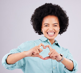 Image showing Black woman, studio portrait and heart hands with afro, smile and romance icon with love, confidence and face. Happy african, model and emoji for happiness, date and romantic sign by gray background