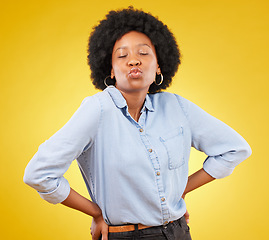 Image showing Flirty, attitude and a black woman with a kiss for love isolated on a yellow background. Young, expression and an African girl showing affection, care and a fashionable look on a studio backdrop