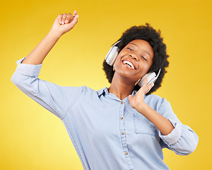 Image showing Black woman, dancing with headphones and freedom, music and happiness on yellow studio background. Happy female, carefree and dance along to radio, audio streaming with fun and energy with technology