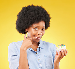 Image showing Black woman, cupcake and studio portrait for smile, temptation or cheat with junk food by yellow background. African model, cake of diet choice for health, nutrition or sweets with decision for meal