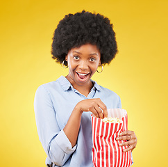 Image showing Surprise, wow and popcorn with black woman in studio for movie, streaming service and cinema. Happy, comedy and theatre with female and snack isolated on yellow background for food, tv and film