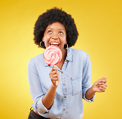 Image showing Eating, candy and lollipop with black woman in studio for colorful, cheerful and positive. Young, happiness and dessert with female isolated on yellow background for treats, food and confectionary