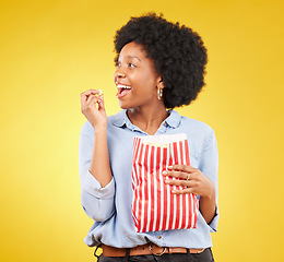 Image showing Happy, eating and popcorn with black woman in studio for movie, streaming service and cinema. Television, smile and theatre with female and snack isolated on yellow background for food, tv and film