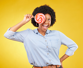 Image showing Excited, candy and lollipop with black woman in studio for colorful, cheerful and positive. Young, happiness and dessert with female isolated on yellow background for treats, food and confectionary