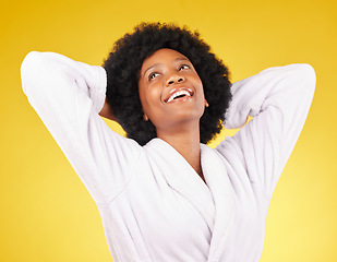 Image showing Black woman relax, bathrobe and happiness in a studio ready for luxury spa treatment for self care. Isolated, yellow background and happy young female with a smile from skincare and wellness