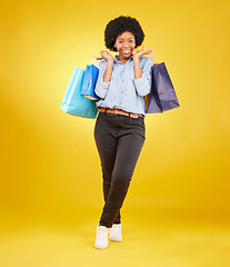 Image showing Black woman with shopping bag, smile with fashion and retail in portrait on yellow studio background. Happiness, female with discount and sale at boutique with designer brand, happy and mockup space