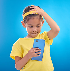 Image showing Phone, stress and child worry on blue background with mistake, accident and guilty expression in studio. Technology, smartphone and young girl with anxiety, stressed out and worried for trouble