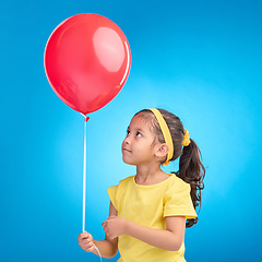 Image showing Young girl, studio and red balloon of a an kid alone ready for a birthday party to celebrate. Celebration event and female child holding balloons in the air with isolated blue background