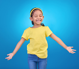 Image showing Mockup, excited and girl with smile, space and celebration against blue studio background. Happy, female child or young person with open arms, happiness and fashion kid outfit with joyful or cheerful