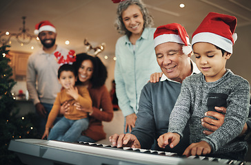 Image showing Piano, christmas and elderly man with grandson in a living room, happy and celebration while bonding in their home. Family, music and retired senior man with boy, festive and learning instrument