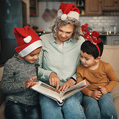 Image showing Christmas, books or reading with a grandmother and kids looking at photographs during festive season. Family, love or celebration with a senior woman and grandchildren holding a story book