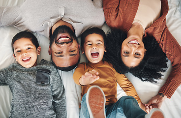 Image showing Laughing, above and portrait of a family on a bed for relaxation, bonding and quality time. Playful, smile and carefree parents with children in the bedroom to relax and play in the morning together