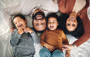 Image showing Laughing, family and top view portrait on bed in bedroom, bonding and care in home. Love, smile and happy mother, comic father and funny children playing, having fun and enjoying joke time together.