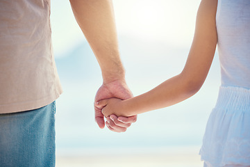 Image showing Holding hands, family or children with a father and daughter outdoor together at the beach during summer. Kids, love or trust with a man and female child standing outside for bonding during the day