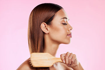 Image showing Woman, brushing hair and hairbrush beauty profile in studio for salon or hairdresser shine shampoo. Haircare of a aesthetic model on a pink background for color, glow or growth cosmetics and grooming