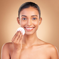 Image showing Smile, skincare and cotton with portrait of indian woman in studio for self care, makeup remover and cosmetics. Beauty, clean and glow with model on brown background for results, natural and facial