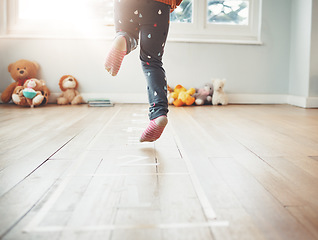 Image showing Hopscotch, happy and feet of child play in home having fun, enjoying games and entertainment in room. Childhood, kindergarten and excited girl in bedroom for jumping game, playing and floor activity