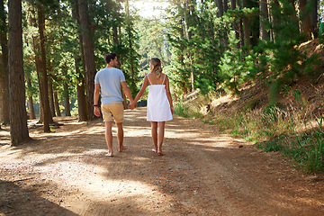 Image showing Nature, forest and couple holding hands walking on a romantic date or hiking adventure together in the woods. Explore, love and people or man and woman in a relationship walk outdoors in a park