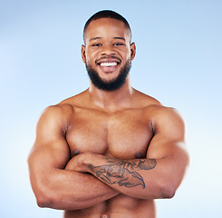 Image showing Muscle, fit and portrait of a black man with arms crossed isolated on a blue background in studio. Happy, pride and African bodybuilder with fitness confidence, arm power and strength on a backdrop