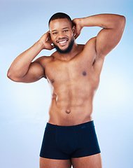 Image showing Black man, fitness and body, smile in portrait and abs, healthy and flex arms, muscle and strong on blue background. Shirtless male in underwear, exercise and bodybuilder with bare abdomen in studio