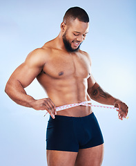 Image showing Black man, fitness and body, weightloss and measuring tape with abs, health and active on blue background. Shirtless male bodybuilder, smile and exercise with diet, healthy and strong in underwear