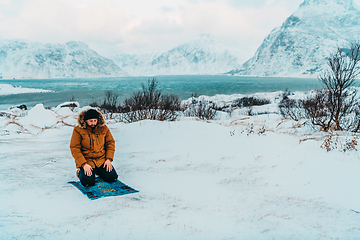 Image showing A Muslim traveling through arctic cold regions while performing the Muslim prayer namaz during breaks