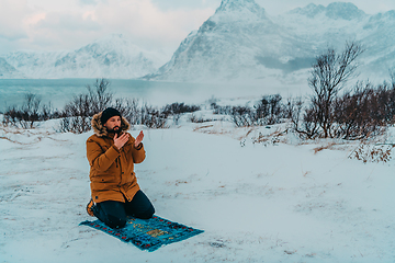 Image showing A Muslim traveling through arctic cold regions while performing the Muslim prayer namaz during breaks