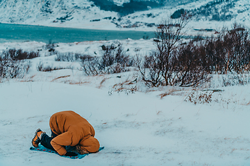 Image showing A Muslim traveling through arctic cold regions while performing the Muslim prayer namaz during breaks