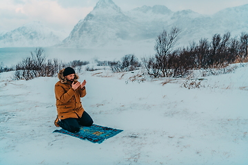 Image showing A Muslim traveling through arctic cold regions while performing the Muslim prayer namaz during breaks