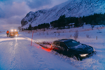 Image showing The roadside assistance service pulling the car out of the canal. An incident on a frozen Scandinavian road.