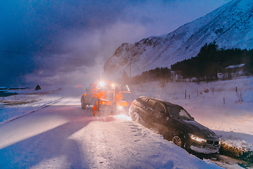 Image showing The roadside assistance service pulling the car out of the canal. An incident on a frozen Scandinavian road.