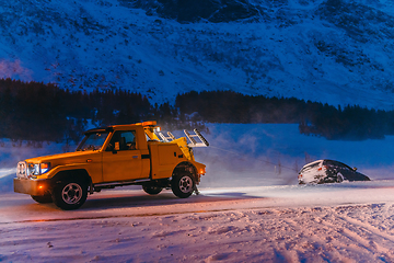 Image showing The roadside assistance service pulling the car out of the canal. An incident on a frozen Scandinavian road.